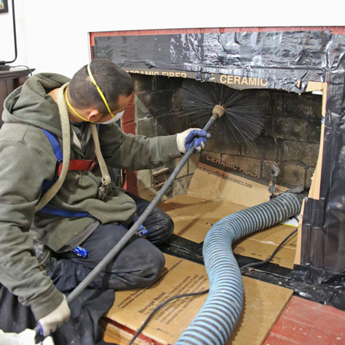 Chimney cleaning in Minnesota removing soot, creosote and accessible debris from a brick fireplace chimney