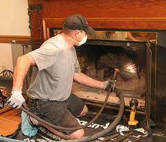 Chimney sweeping in Minnesota removing creosote and soot from a fireplace flue with professional brushes